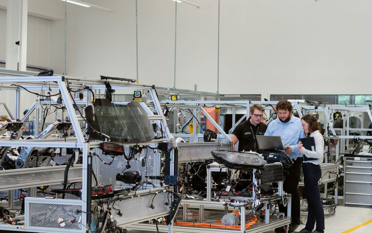 Engineering professionals discussing production equipment and process performance in a manufacturing facility.